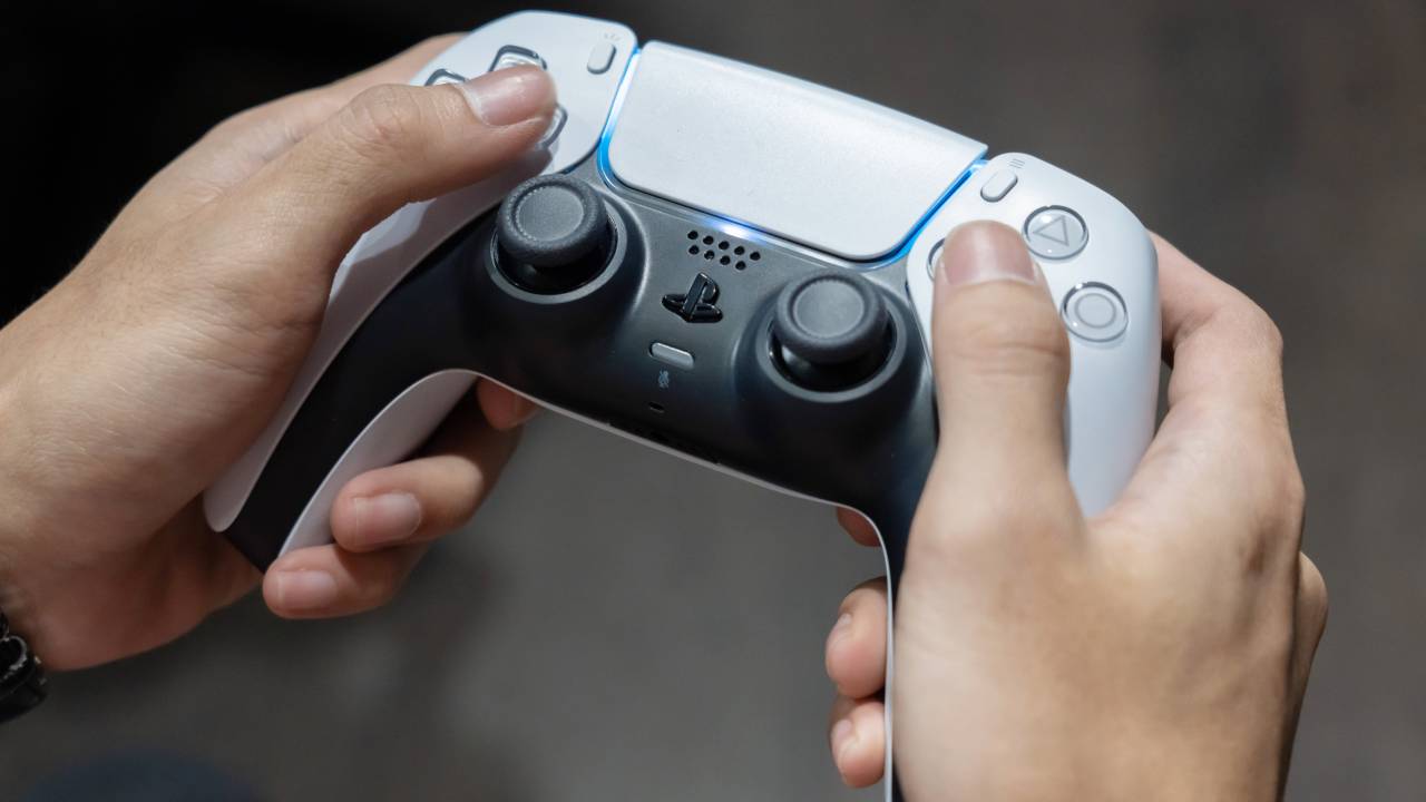 Una persona in possesso di un controller DualSense PS5
