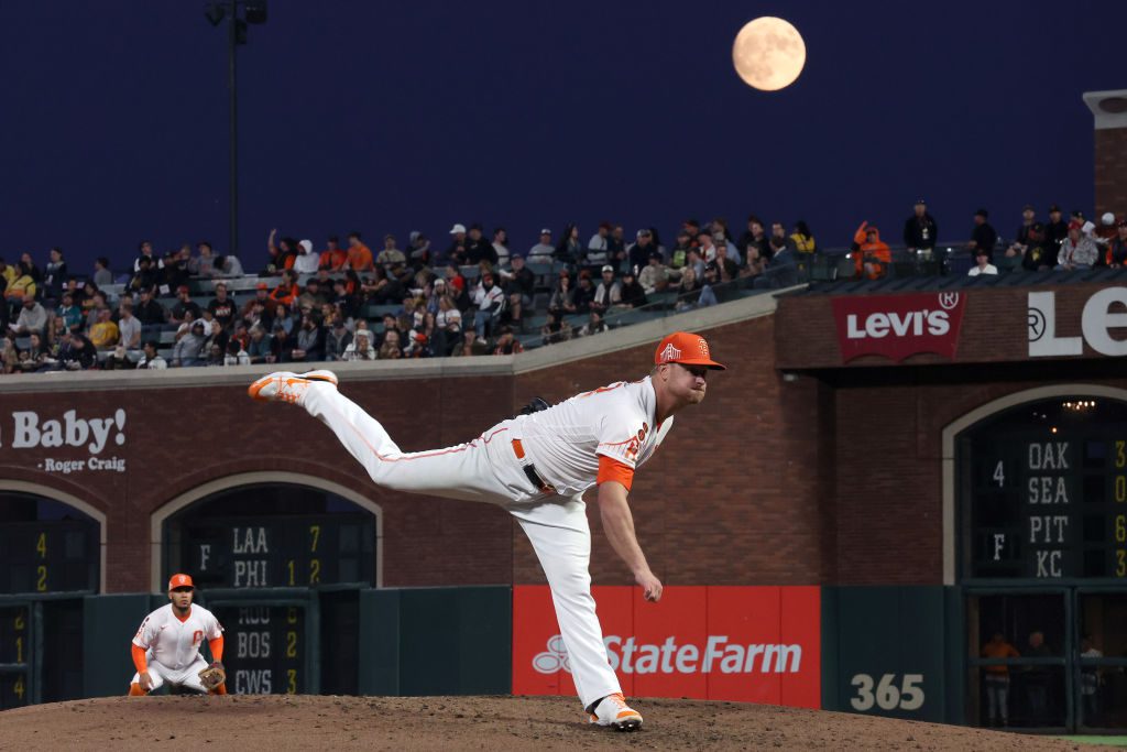 Una gigantesca luna blu brilla sopra una partita di baseball mentre un giocatore corre in avanti.