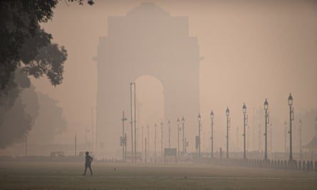 Un uomo cammina sui prati di Kartavia Road vicino all’India Gate a Nuova Delhi