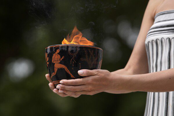 Un artista tiene in mano una ciotola di ceramica contenente la torcia durante la cerimonia ufficiale di accensione della torcia per le Olimpiadi di Parigi, nel sito dell'antica Olimpia, in Grecia, martedì 16 aprile 2024. (AP Photo/Thanassis Stavrakis)