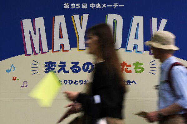 La gente cammina verso il luogo della marcia del Labor Day a Tokyo, mercoledì 1 maggio 2024. (AP Photo/Hiro Komae)